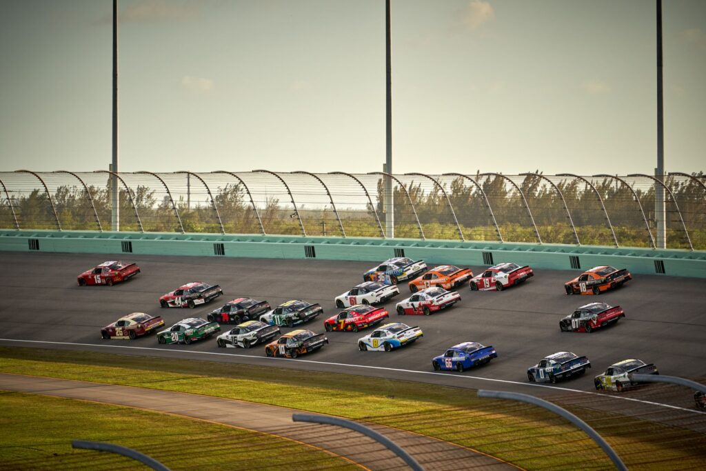 NASCAR Cup Series stock cars racing in a pack on an oval track